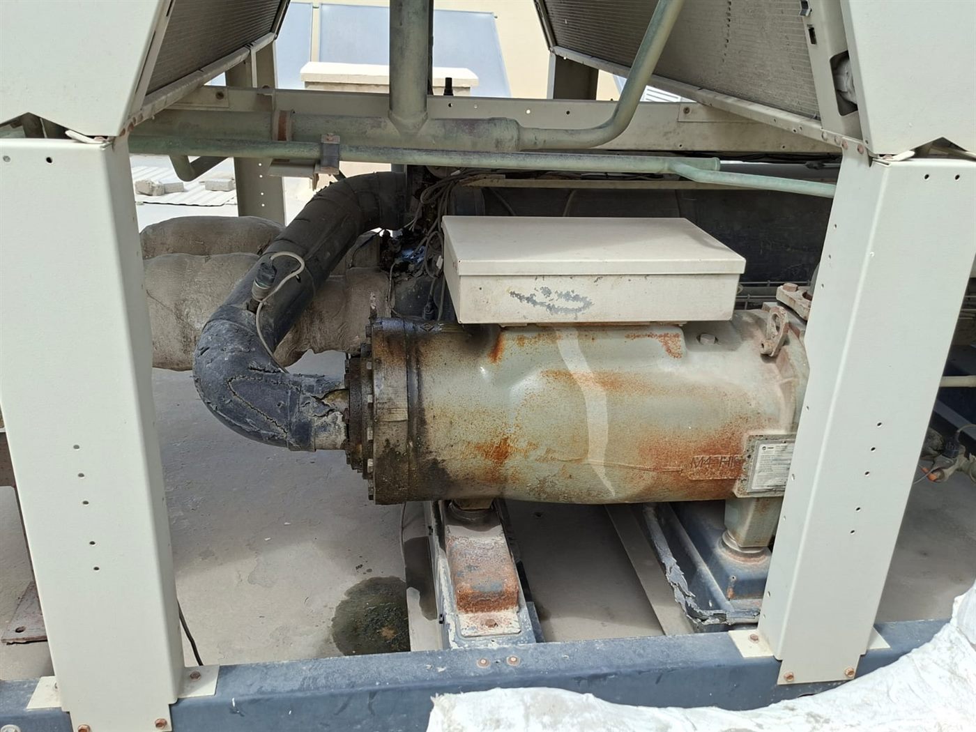 Air-cooled chiller compressor removed for overhaul on a rooftop plant deck