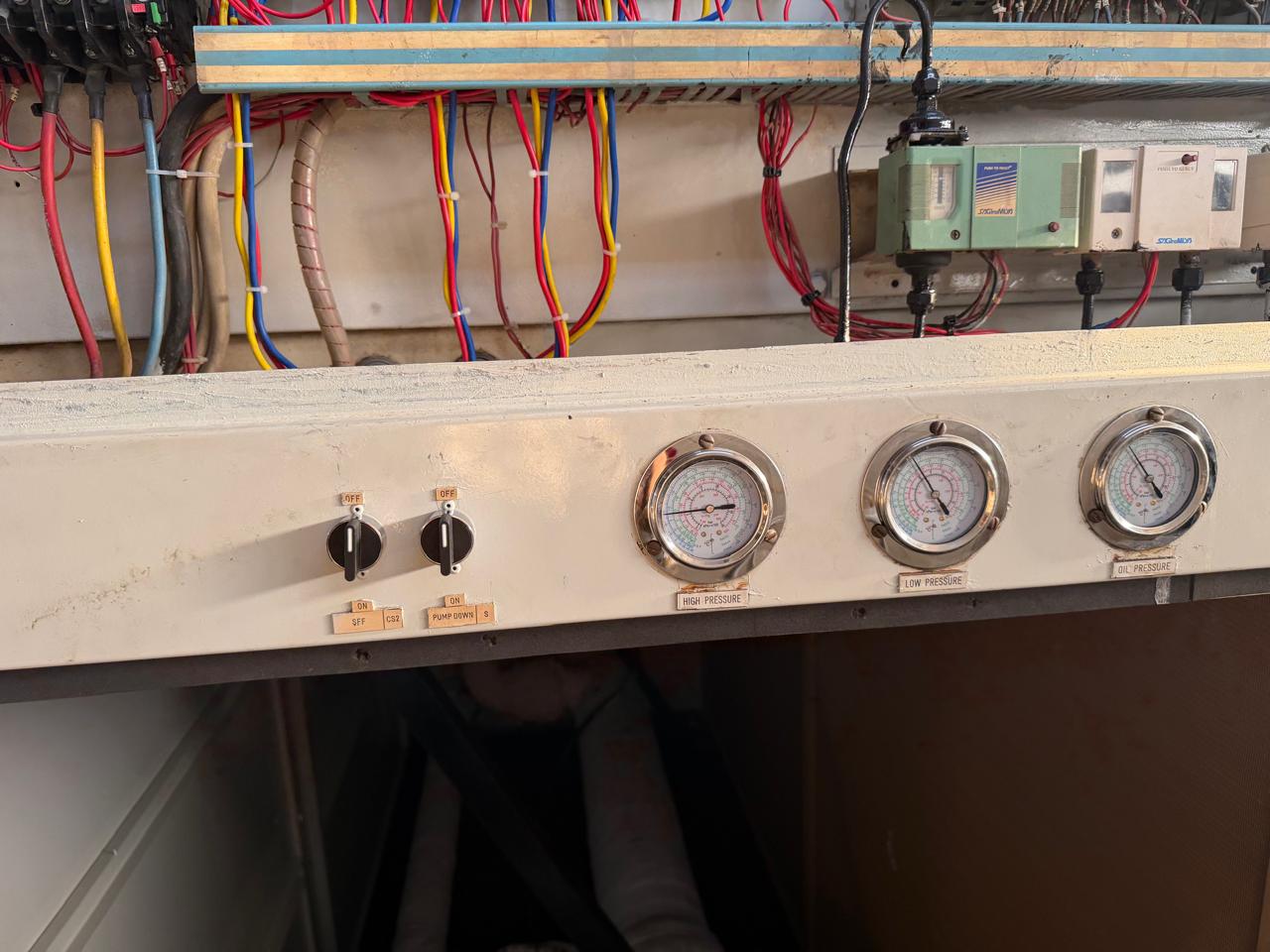 Control panel wiring with high pressure, low pressure and oil pressure gauges in a chiller plant room